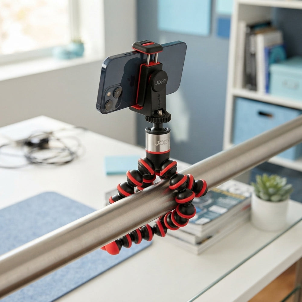 JOBY GorillaPod 500 with a smartphone mounted, wrapped around a metal railing in a bright, modern studio workspace.